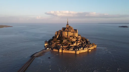 A castle on a small island with Mont Saint Michel in the background