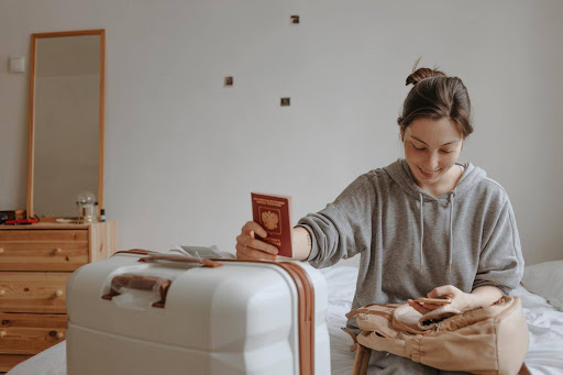 Woman with the baggage and passport at home preparing to flight